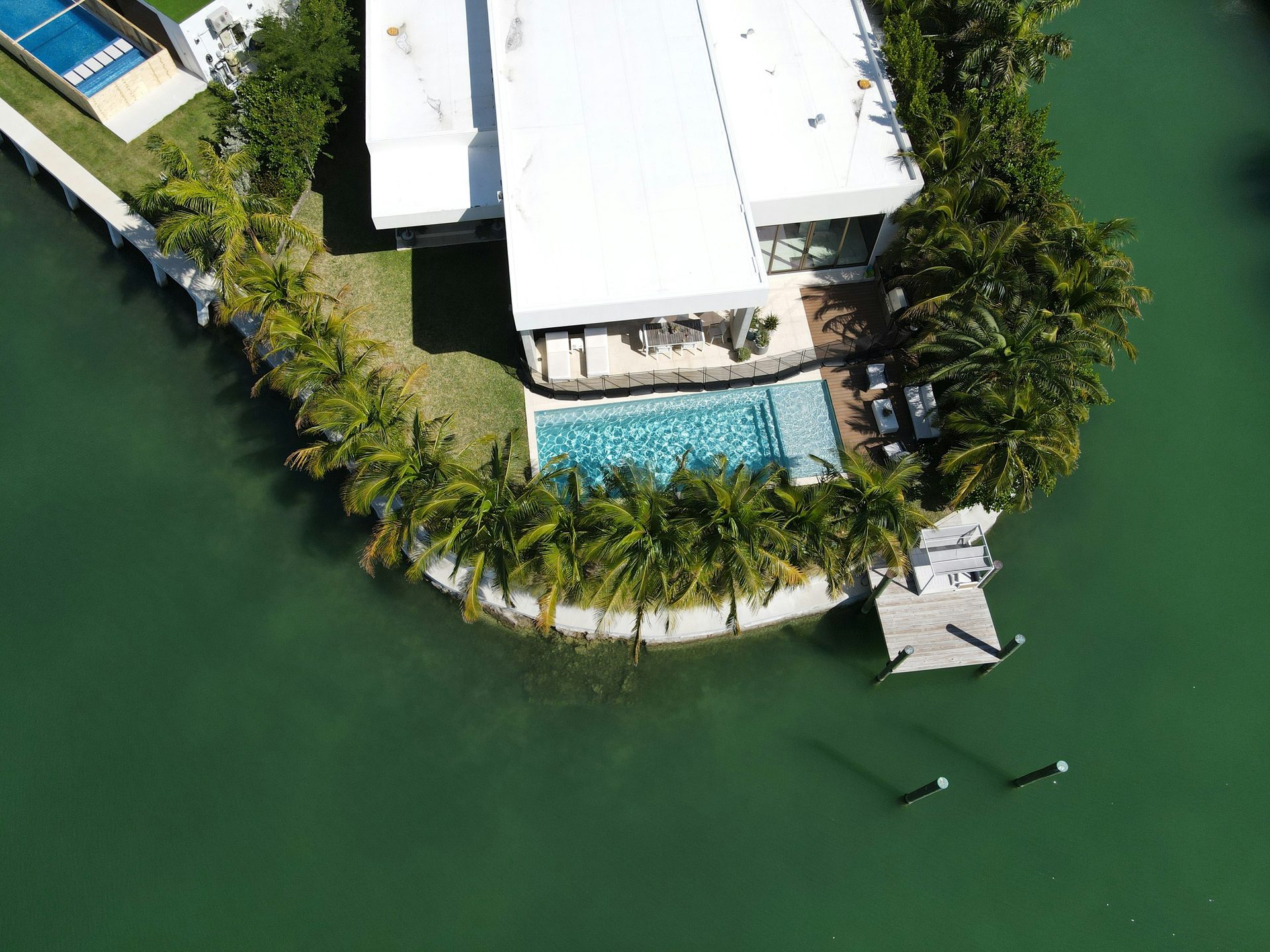 Aerial view of a Florida waterfront home with palms and a private pool