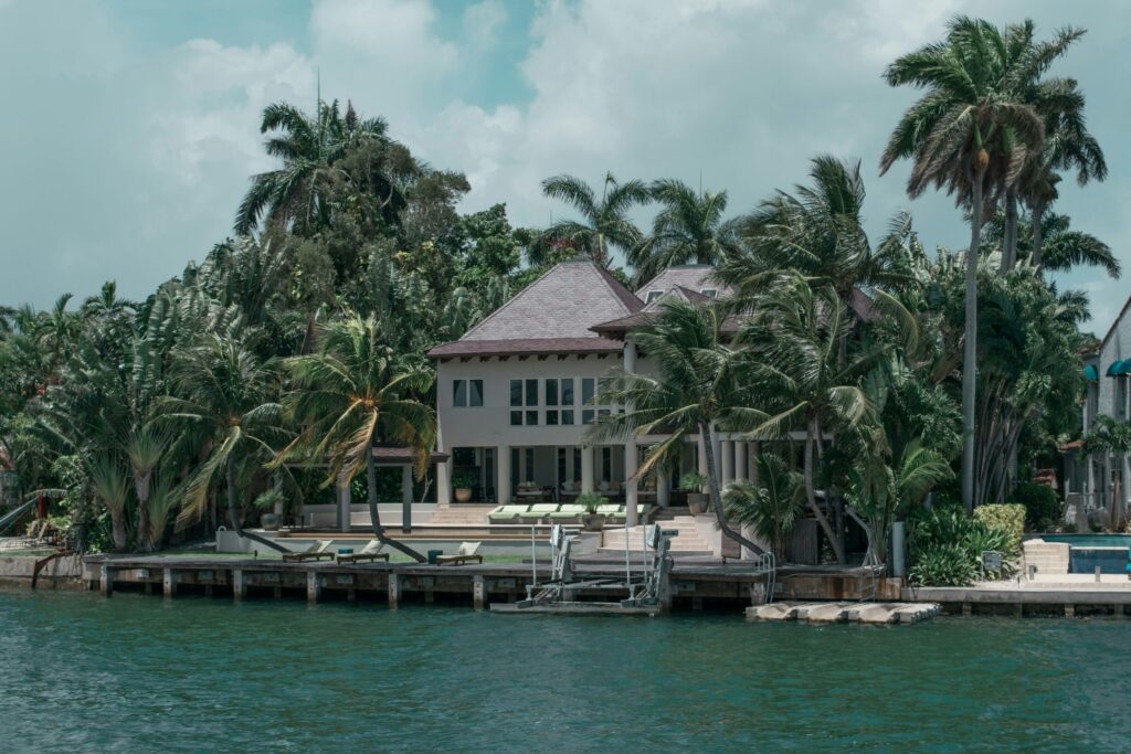Florida bayfront home framed by palm trees, viewed from the water